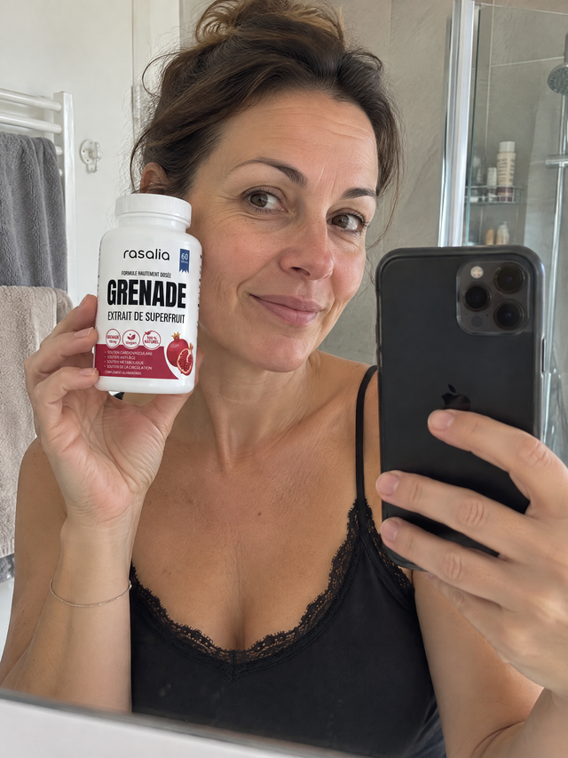 Une femme dans sa salle de bains, une boîte de grenade Rasalia près du visage