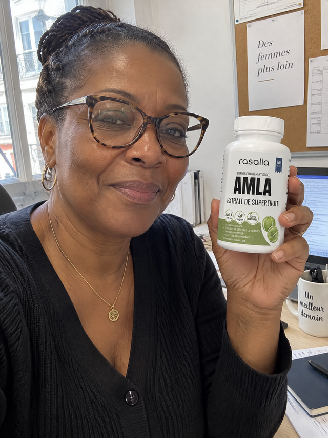 Une femme à son bureau, une boîte d'amla Rasalia à la main